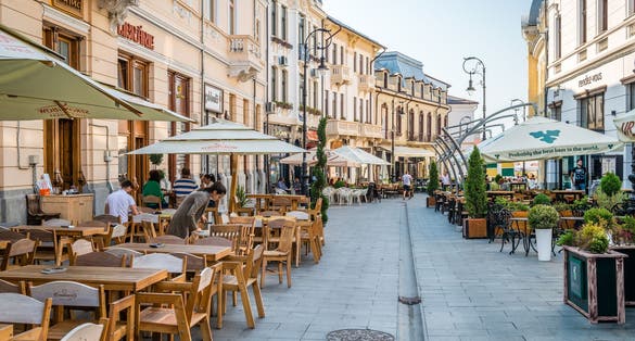 Photo of People are sitting in cafes on Alexandru Ioan Cuza street in Craiova, Romania.