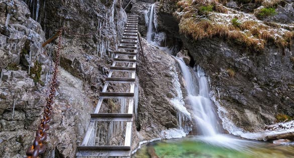 Waterfall with ladder in canyon, sucha bela.Icefall in the gorge of Slovak paradise national park. Winter hiking trail with ice structures and steel climbing ladder. Adventure travel in Slovakia