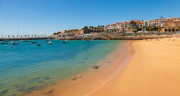 Photo of beach, town and dock of Cascais at summer, Portugal.