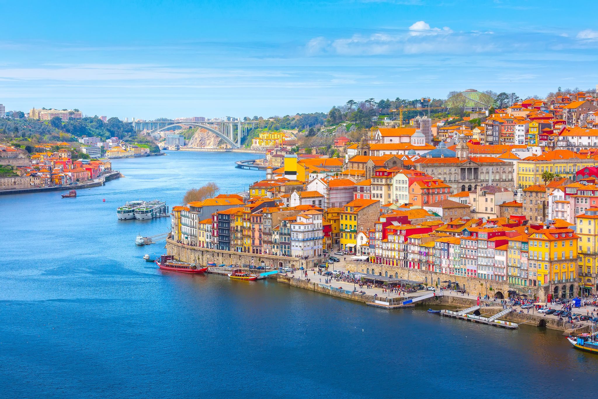 Porto, Portugal old town ribeira aerial promenade view with colorful houses, Douro river and boats.