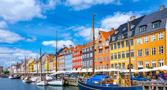 Photo of Scenic summer view of Nyhavn pier with colorful buildings and boats in Old Town of Copenhagen, Denmark.