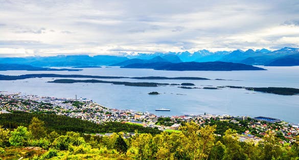 photo of view of Molde, Norway. Aerial day view of Molde, Norway during the cloudy afternoon. Beautiful fjord with snowy mountains in summer