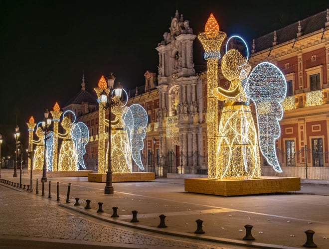 Christmas lights decoration in the shape of an angel holding a torch in from of The Palace of San Telmo, In Seville.jpg