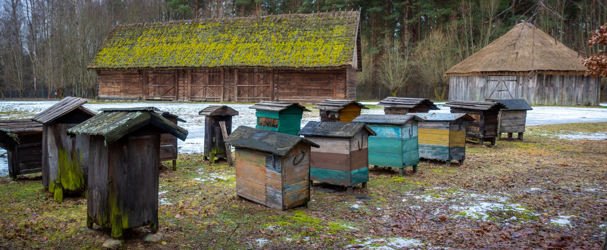 Old hives on display in the open-air museum of folk culture. The photo was taken on a cloudy winter day.