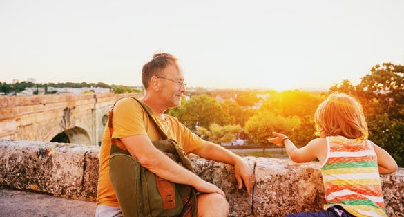photo of happy tourists, father and son enjoying sunset at Saint Clement Aqueduct in Montpellier, France.