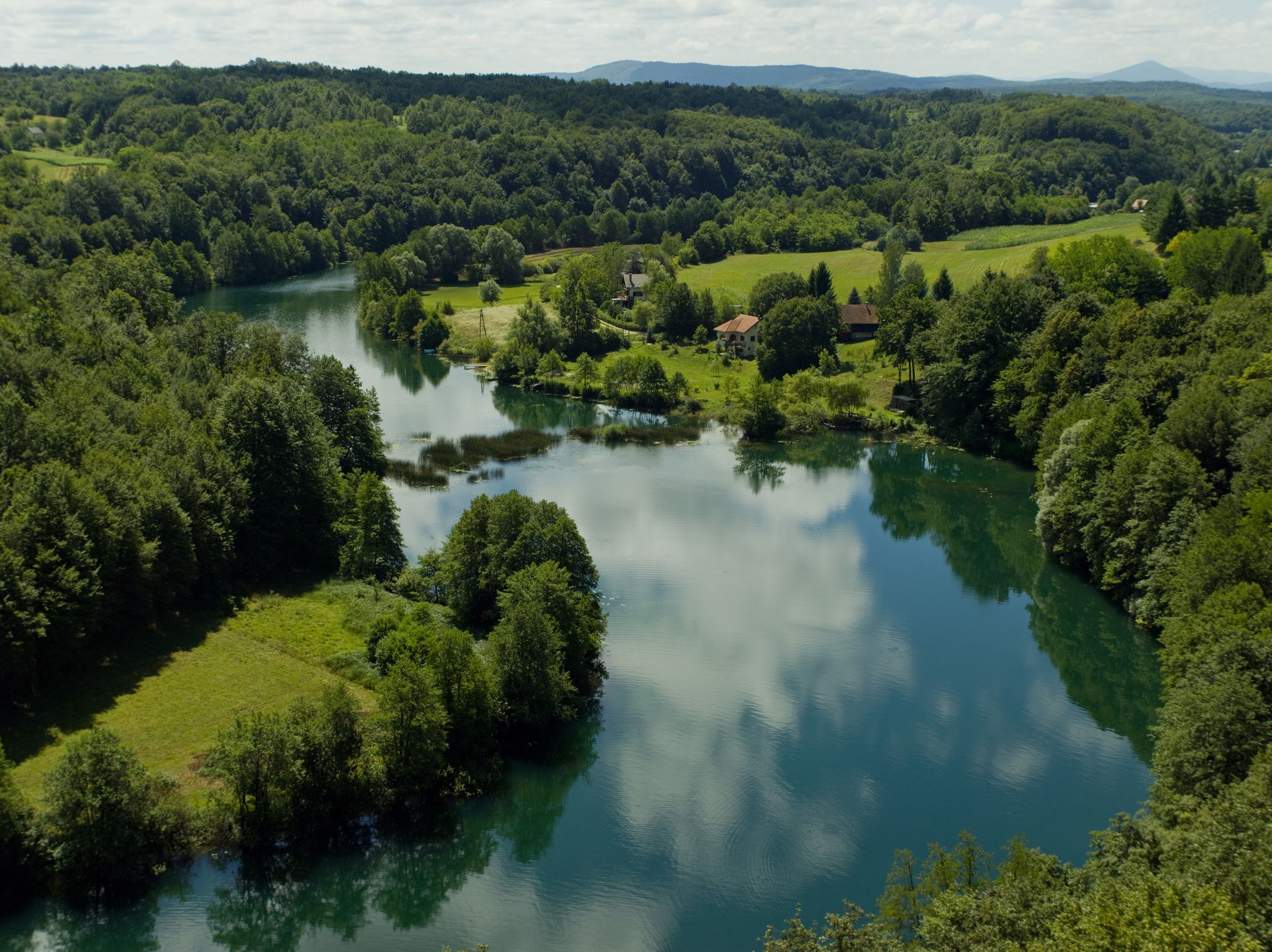 photo of view of A landscape of The Mreznica surrounded by greenery on a sunny day in Karlovac County, Croatia