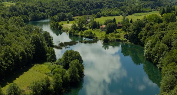 photo of view of A landscape of The Mreznica surrounded by greenery on a sunny day in Karlovac County, Croatia