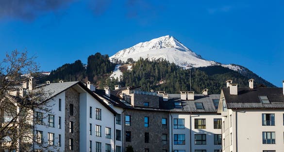 Photo of A hotel with the Bansko Ski Resort on the Pirin Mountains at the background in Bansko, Bulgaria.