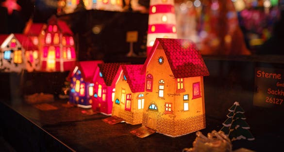 photo  of view of  Essen, Germany - December 13, 2022: Christmas atmosphere at the open xmas market. Celebrating Xmas holidays. Lights, carousel, small houses, toys and decorations at fair in European city or town