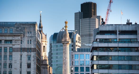 Photo of Monument tower in London shot from the southbank at sunrise on a beautiful sunny day, UK.