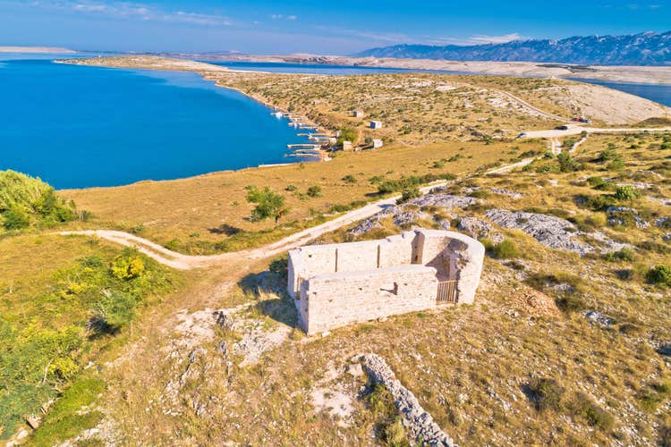 Vrsi bay and saint Lovre church ruin aerial view, stone desert of Zadar archipelago of Croatia