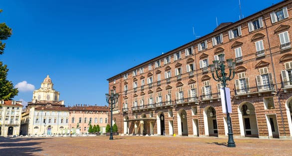 Prefecture Palazzo del Governo Palace buildings and San Lorenzo Saint Lawrence church on Castle Square Piazza Castello in historical centre of Turin Torino city with clear blue sky, Piedmont, Italy.