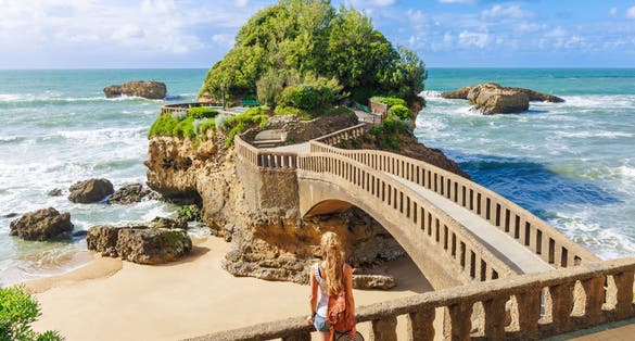 Photo of tourist on the famous bridge to the island, Biarritz, France.