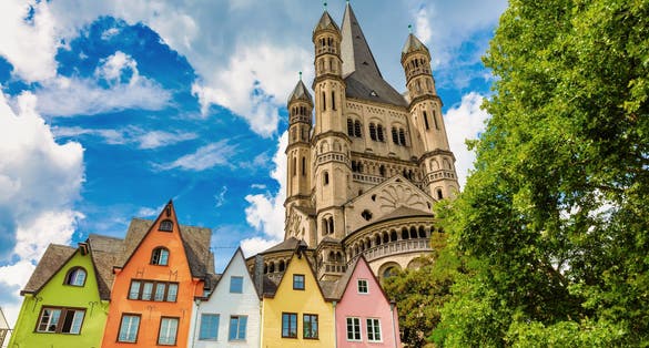 Photo of church Gross St Martin with unique colorful houses in the old town of Cologne, Germany.