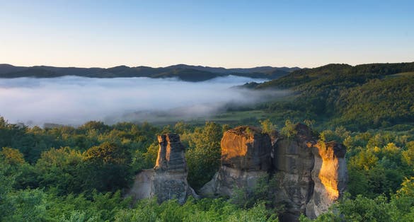 Photo of The rock towers of the Dragons Garden (Gradina Zmeilor ), a protected geological nature reserve in Salaj, Transylvania region, Romania, at sunrise, in summer foggy morning .