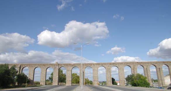 Água de Prata aqueduct on a road under a blue sky in the city of Evora - Portugal