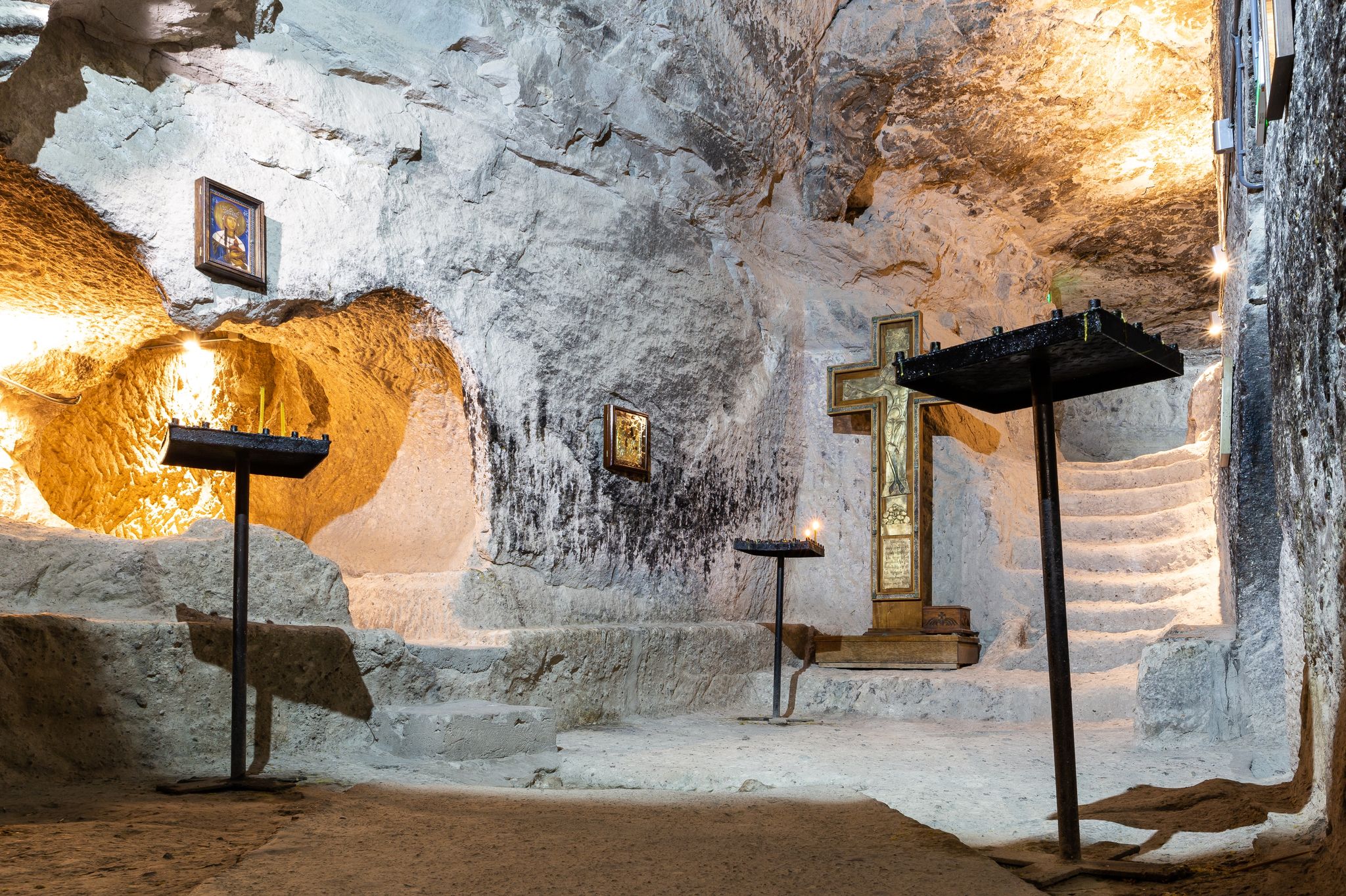 Photo of Remains of the Old Church carved in the rock in Vardzia Cave Monastery complex in Georgia with stone walls, orthodox icons and cross.