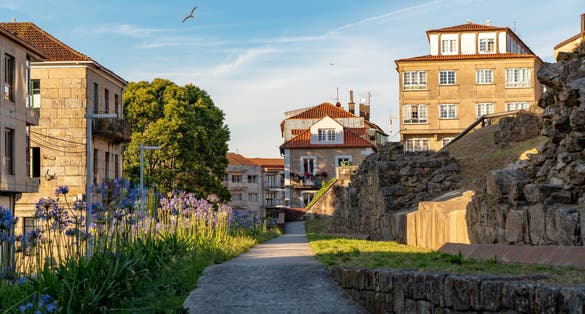 Photo of beautiful streets of Pontevedra city. Galician houses with flowers at balconies, Spain.
