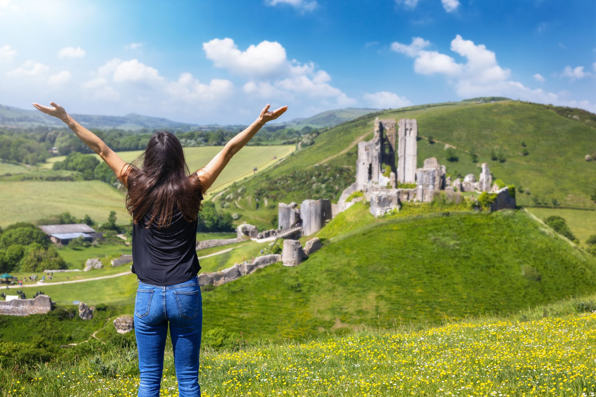 Photo of a tourist woman looks at the ruins of Corfe Castle, Dorset, England.