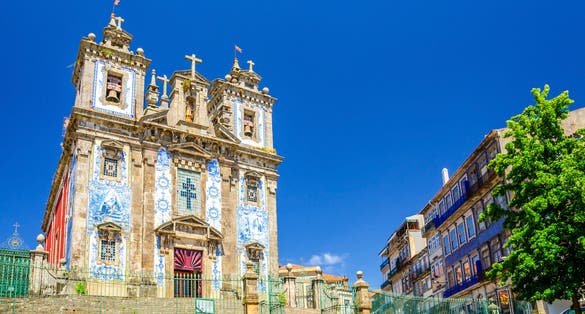 Photo of Saint Ildefonso Roman Catholic church in Batalha Square in Porto Oporto city historical centre, clear blue sky in sunny summer day background, Norte or Northern Portugal.