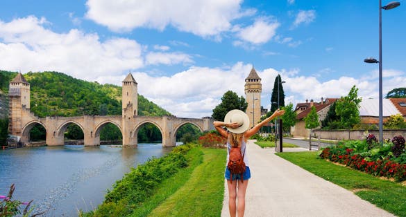 Photo of woman traveling in France-Lot, Cahors city landscape with river and bridge.