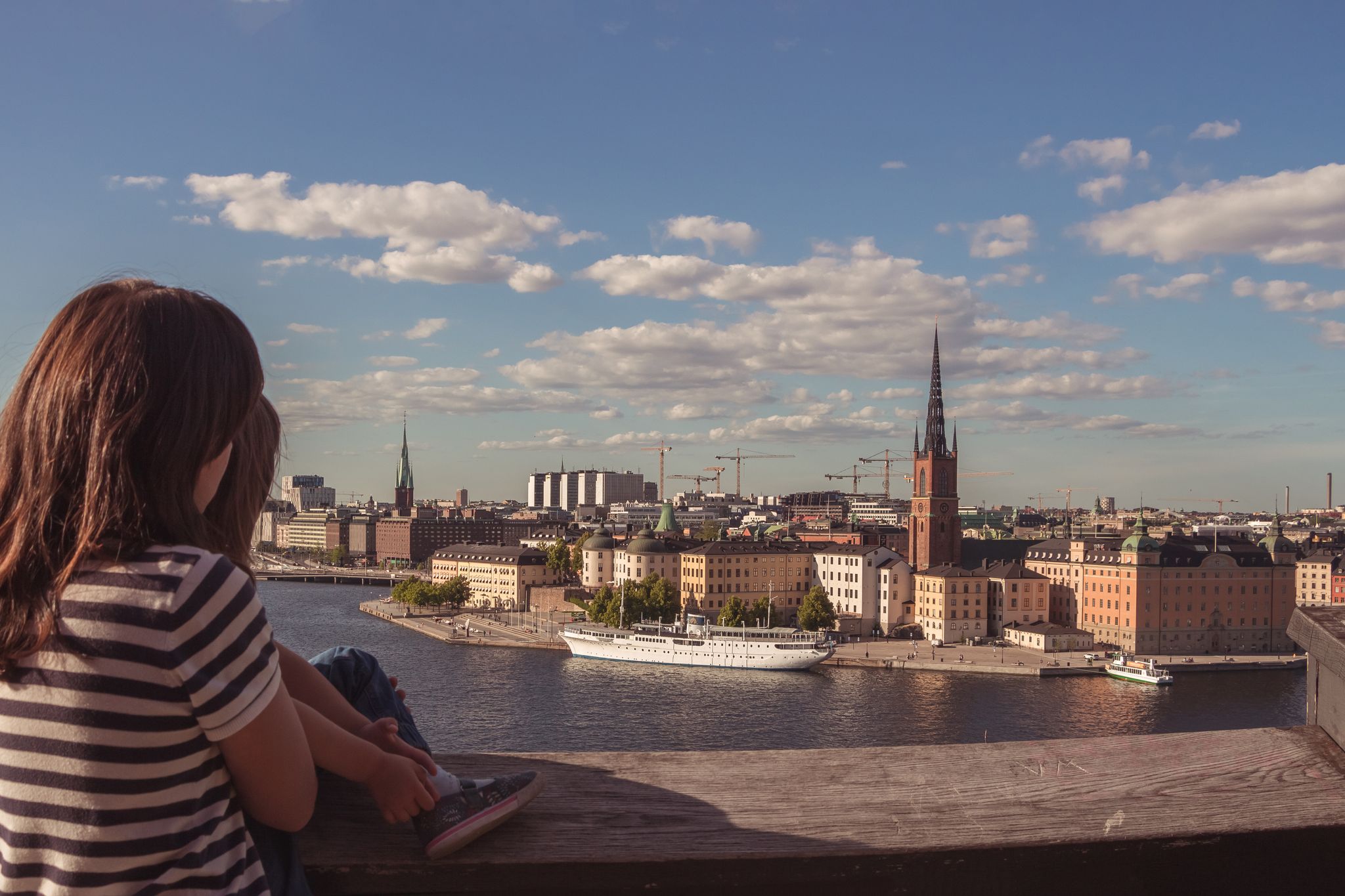 photo of panoramic view of mother and daughter with Riddarholm and Gamla Stan, view from Sodermalm in Stockholm, Sweden.