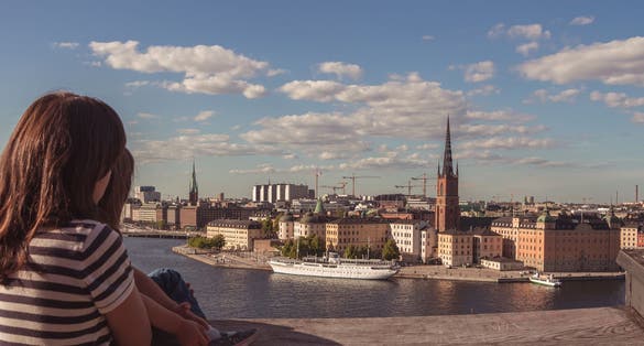 photo of panoramic view of mother and daughter with Riddarholm and Gamla Stan, view from Sodermalm in Stockholm, Sweden.