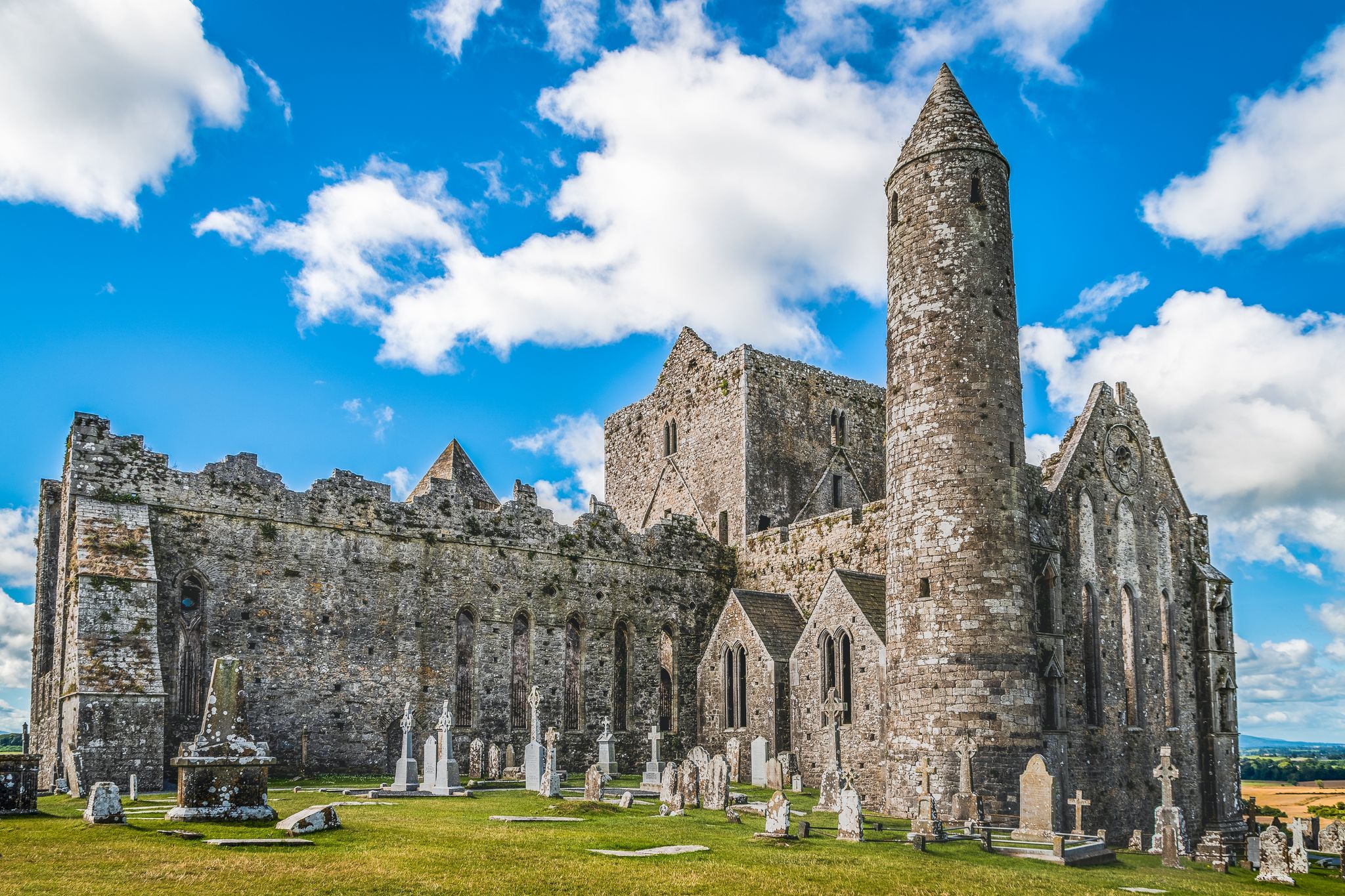 Photo of Ruins of the medieval old huge cathedral among tombstones on Rock of Cashel, Ireland.