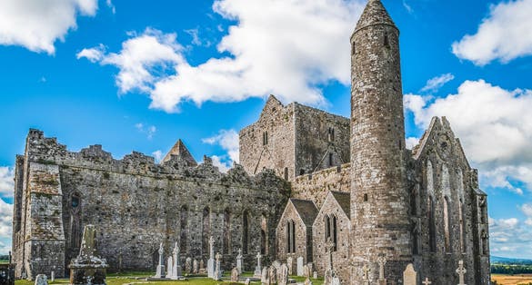 Photo of Ruins of the medieval old huge cathedral among tombstones on Rock of Cashel, Ireland.