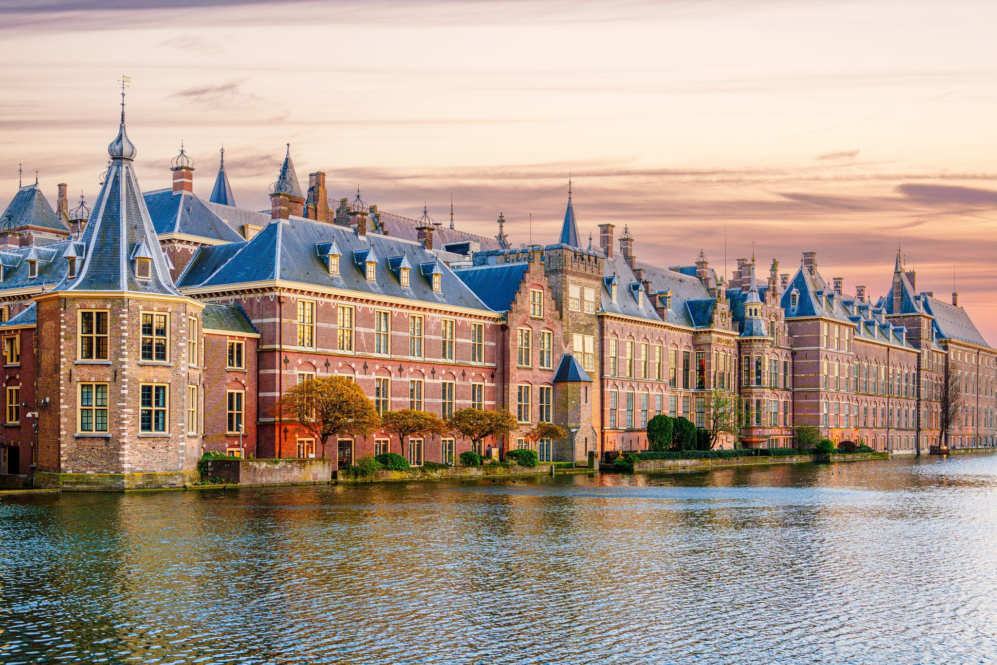 photo of the Hague, Binnenhof with the Hofvijver lake at sunset. Meeting place of states general of the Netherlands, the ministry. Office of the prime minister of Netherlands.
