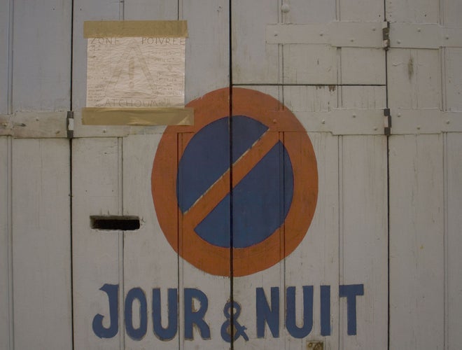 Hand-painted no parking sign with -Jour & Nuit- text on a garage door in Marseille, France..jpg