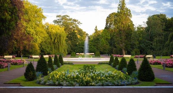 photo of flower arrangements in symetrical shapes leading up to a fountain in the city park Stadsparken in the town Lund, Sweden.