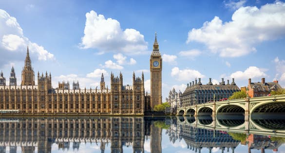 photo of summer view of the Westminster Bridge and Palace with Big Ben clocktower in London, England, with sun, clouds and reflections in the river Thames.