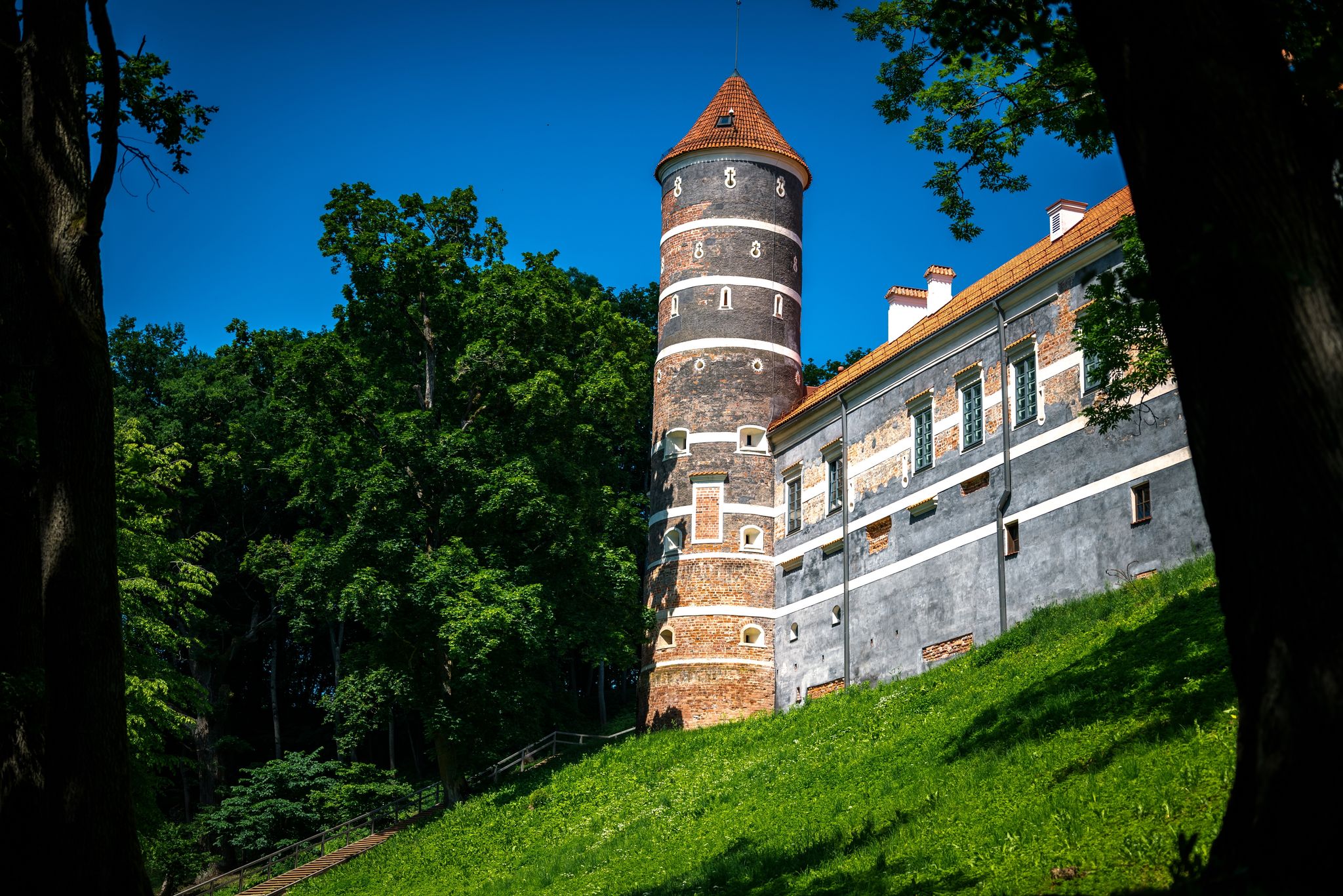 Panemune Castle with green trees and blue sky. Castle on the right bank of the Nemunas river, in Vytėnai, Jurbarkas district, Lithuania. One of the most beautiful Renaissance era building in Lithuania