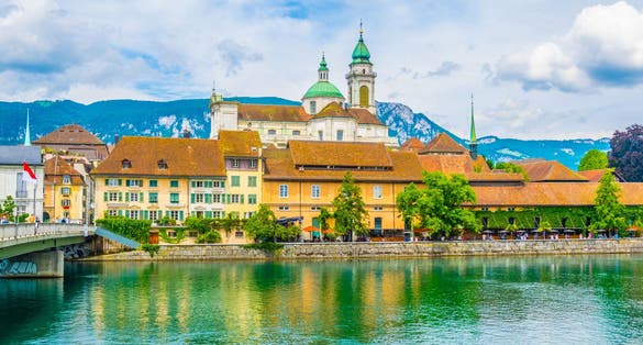 photo of riverside of Aare passing through Solothurn is dominated by Saint Ursus Cathedral, Switzerland.