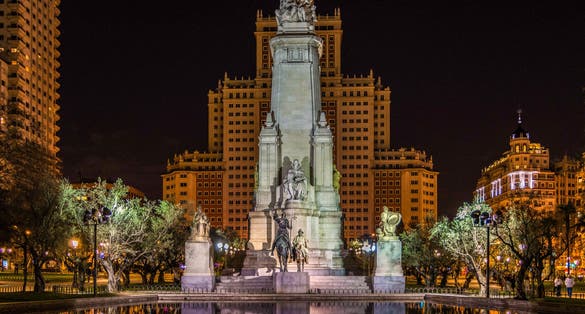 Photo of Monument to Miguel de Cervantes reflected in the water, in the Plaza de España in Madrid.