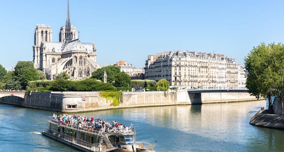 Photo of tourist cruise in River Seine Paris with Cathedral Notre Dame Reims Champagne, France.