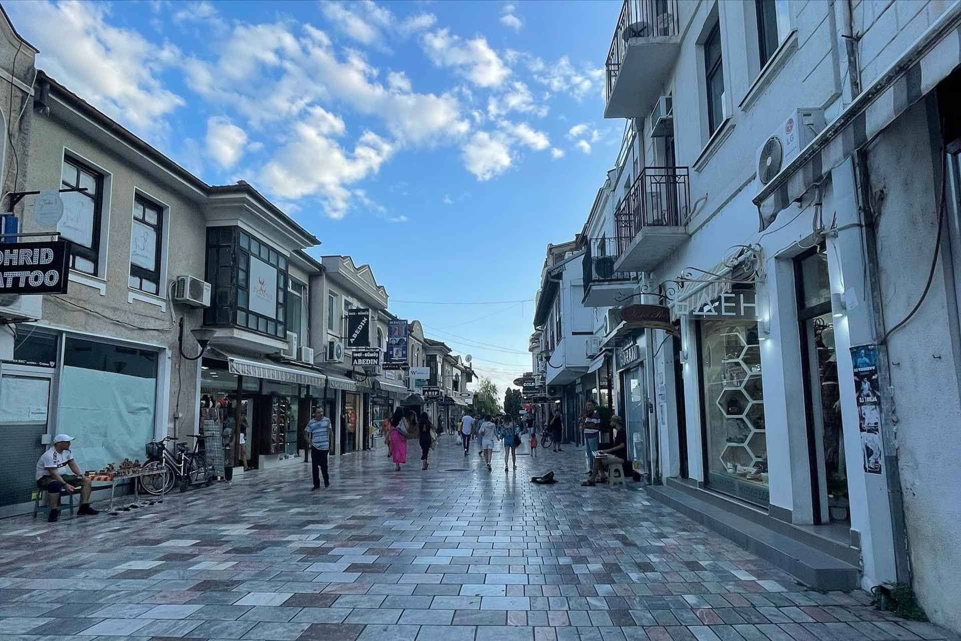 A pedestrian street with shops and people walking in the Old Bazaar of Ohrid, North Macedonia, on a sunny day..jpg