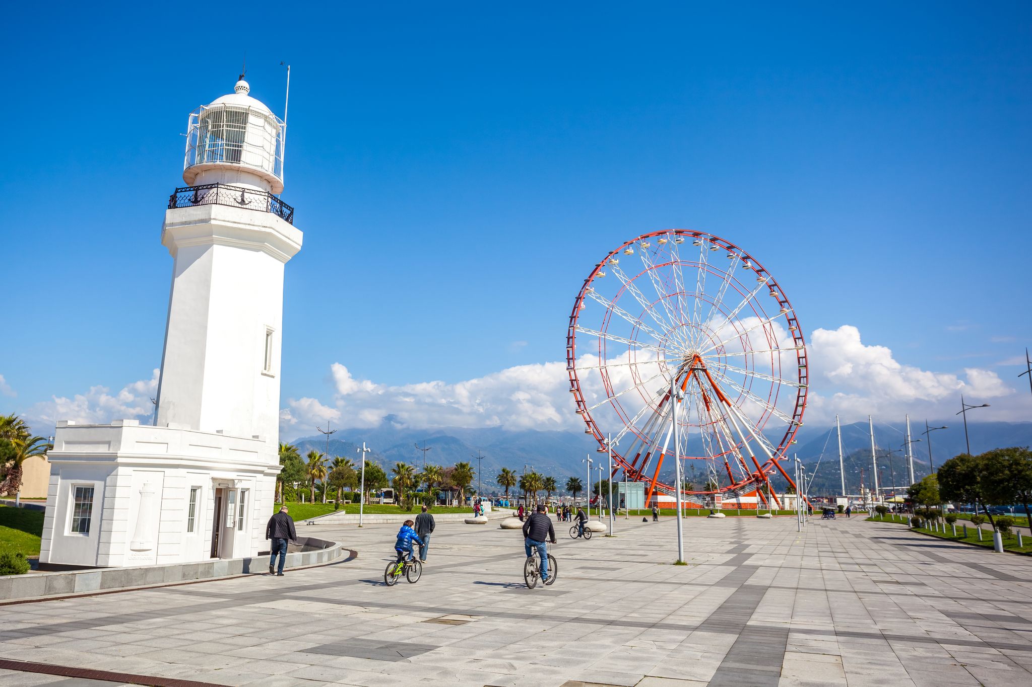 Photo of Ferris wheel and Batumi lighthouse on the Batumi Seafront Promenade on a sunny day, Georgia.