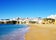 Photo of wide sandy beach in white city of Albufeira, Algarve, Portugal.