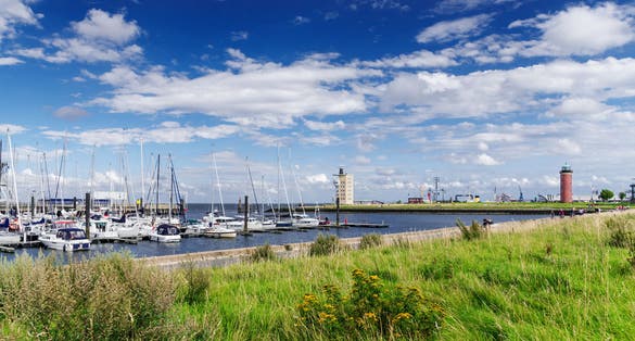 Photo of waterfront in Cuxhaven, Germany with lighthouse in background.