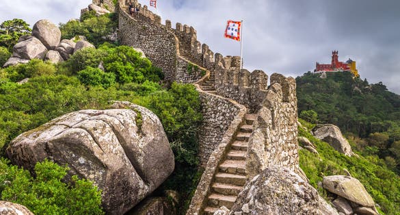 Photo of Castle of the Moors wall with Pena National Palace in the distance, Sintra, Portugal.