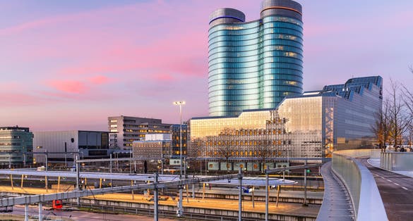 photo of view  of Utrecht, Netherlands cityscape over train station platforms at dawn.