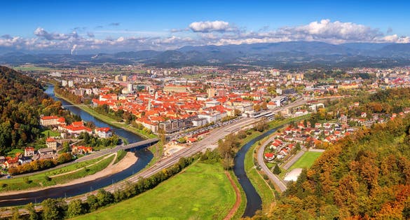 Large panorama of Celje city in Slovenia, aerial view from old castle ancient walls. Amazing landscape with town in Lasko valley, river Savinja and blue sky with clouds, outdoor travel background