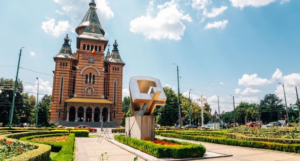 Photo of Victory Square with the Orthodox Cathedral, Timisoara is a long square with green park surrounded by national opera on one side and the metropolitan cathedral on the other.