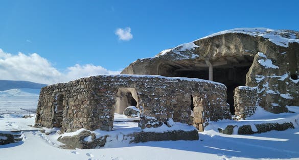 Photo of Uplistsikhe covered in snow that is an ancient rock  hewn town near Gori in Shida Kartli region of Georgia