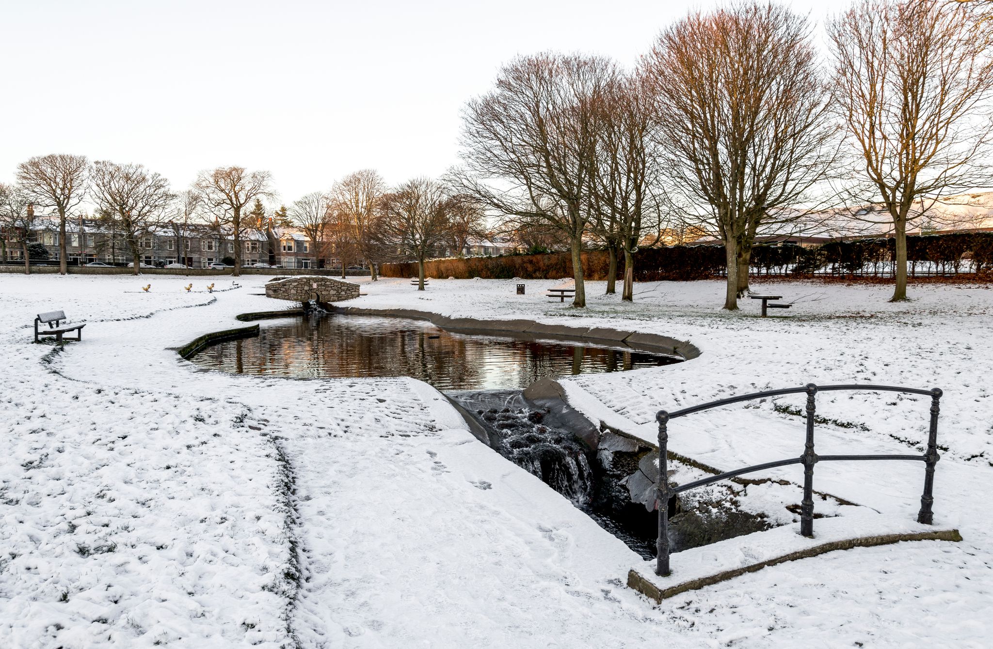 Photo of A small artificial pond and river in Westburn park during winter season, Aberdeen, Scotland .