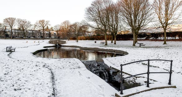Photo of A small artificial pond and river in Westburn park during winter season, Aberdeen, Scotland .