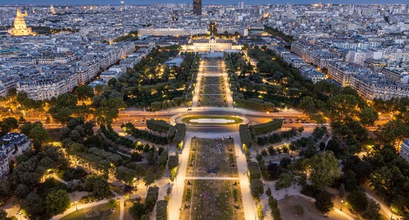 Photo of Champ de Mars at night view from top of Eiffel tower looking down see the entire city as a beautiful classic architecture.