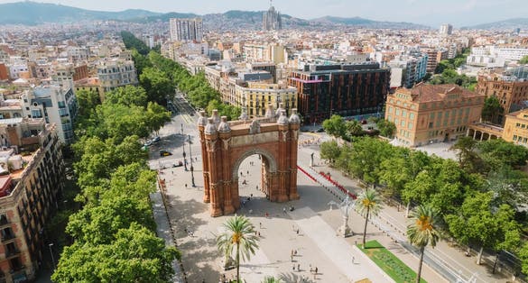 Photo of aerial view of Barcelona Urban Skyline and The Arc de Triomf or Arco de Triunfo in spanish, a triumphal arch in the city of Barcelona.